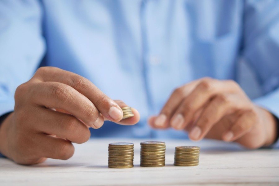 Person stacking coins to represent growing savings